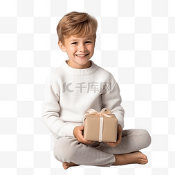 男孩礼物图片_一个穿着白色毛衣的男孩坐在圣诞