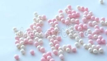小珍珠母白色和粉红色球或化妆粉珠滚动在白色背景，最小的想法概念，4k
