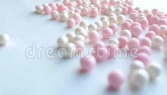 小珍珠母白色和粉红色球或化妆粉珠滚动在白色背景，最小的想法概念，4k