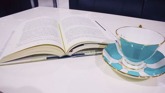 摊开的书本和蓝色茶杯