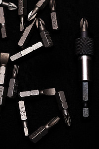 金属样式摄影照片_工具碳钢钻头，带钻头支架，黑色背景，深色钥匙样式。