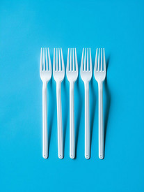 蓝色背景中的一次性餐具白色塑料叉