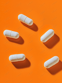 橙色背景中的白色药物胶囊