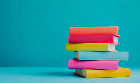 蓝色背景上五颜六色的书籍堆栈带有复印空间回到学校概念