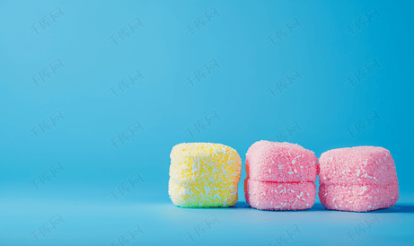 蓝色背景中三块彩色棉花糖创意甜点