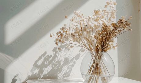 白桌上玻璃透明花瓶中的干花花束