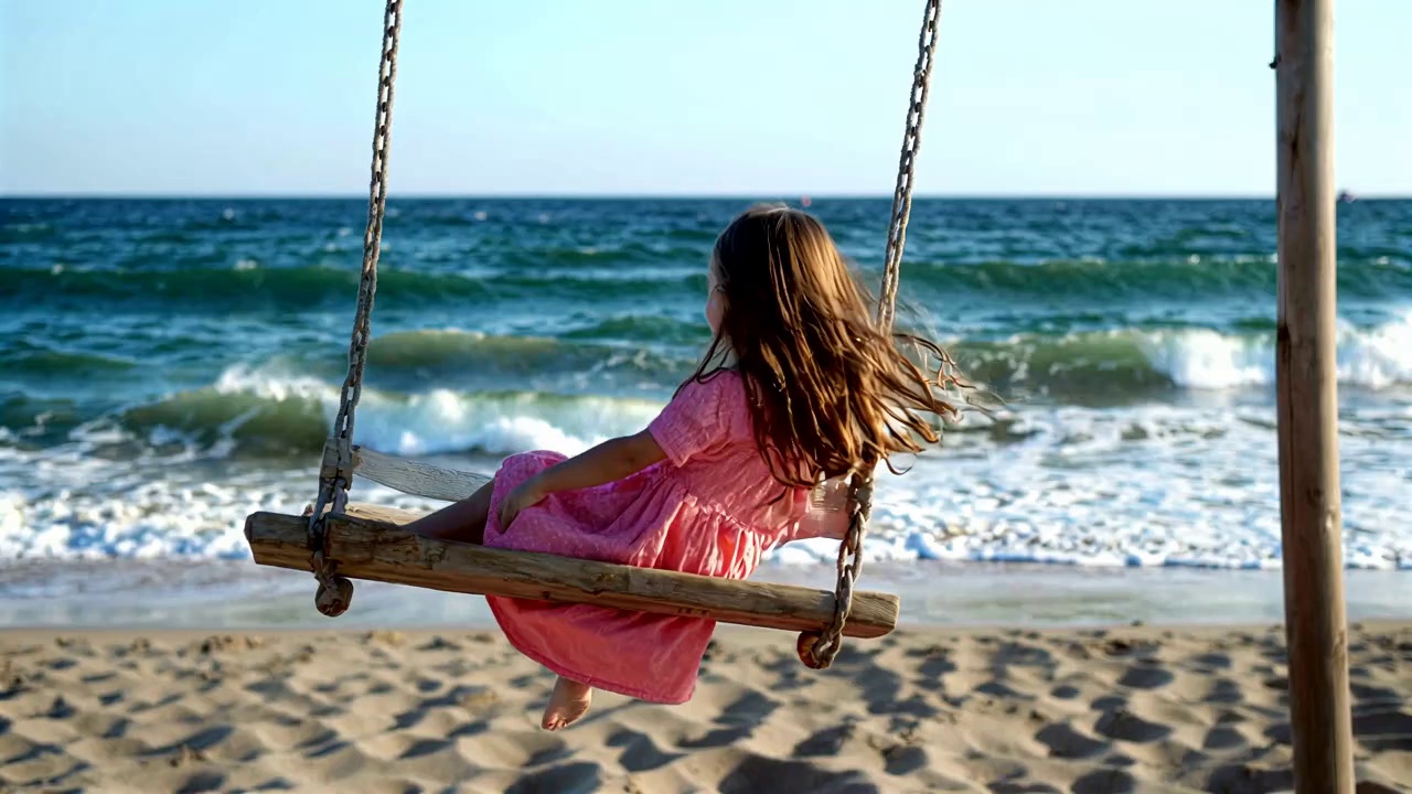 在海边荡秋千的女孩背影