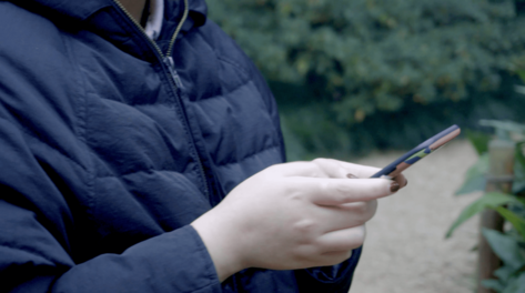 特写拍摄女生走路玩手机