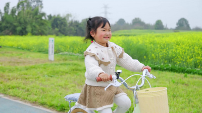 4K油菜花田儿童骑行春日场景视频素材实拍素材
