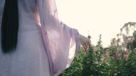 4k古风汉服女孩夕阳下在花丛行走古风古装美女背影