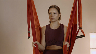 吊床室内藤吊椅图片素材_坐在瑜伽馆吊床上的女人吊在吊床上练空中