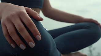 女人双手平躺在莲花中摆出近距离的姿势一个不知名的女孩在练瑜伽