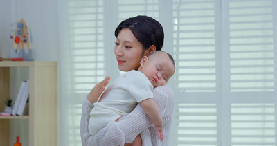 年轻妈妈抱着睡觉的宝宝2