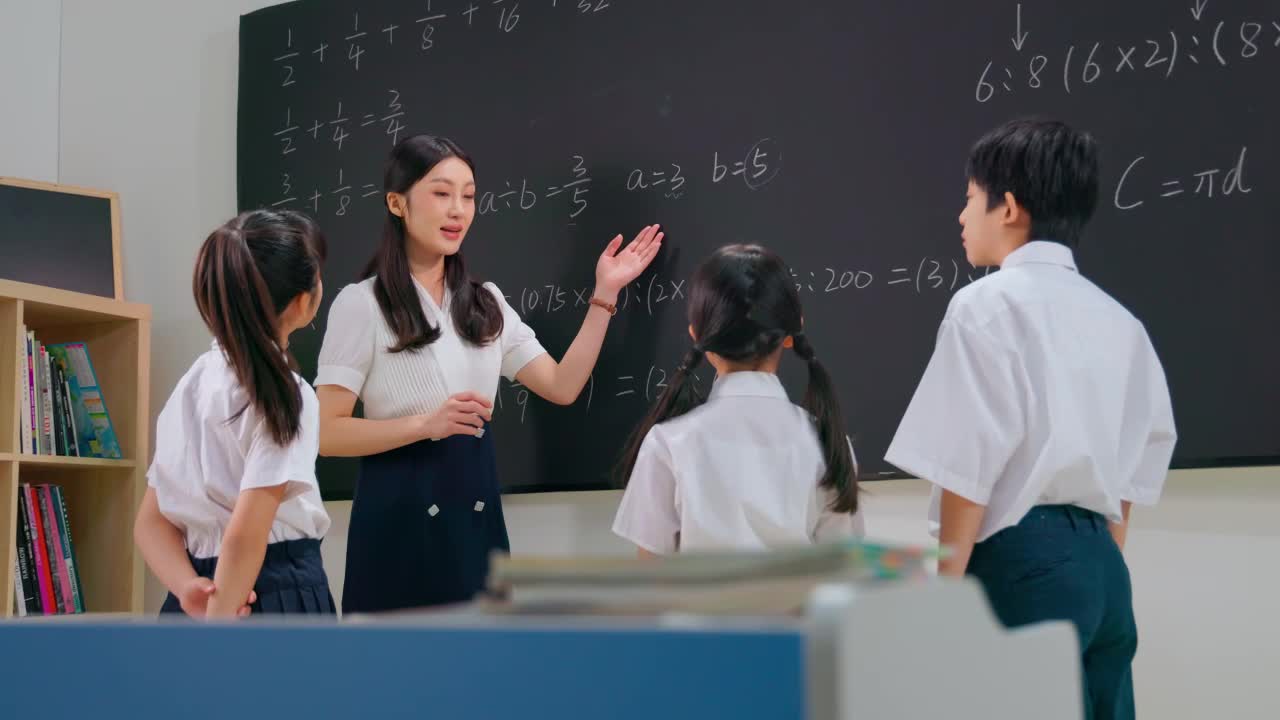 年轻老师给小学生们讲解数学题视频特效素材-千库网