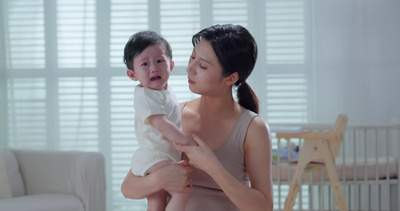 年轻妈妈抱着哭闹的宝宝1