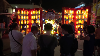 中国游客在用灯笼装饰的老鼠雕像拍照