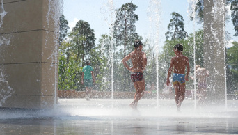 炎炎夏日孩子们在城市喷泉里游泳孩子们玩喷泉