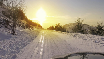 在积雪较多的林路上冬天的汽车和降雪