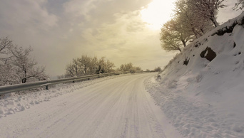 在积雪较多的林路上冬天的汽车和降雪