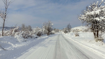 冬天下雪在山路上开车汽车在积雪的路上的个人视角
