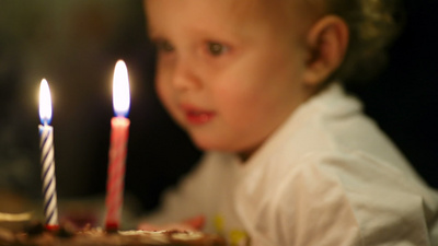 小男孩吹灭了生日蛋糕上的两根蜡烛