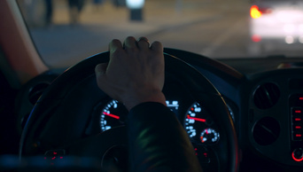 手放在汽车的方向盘上夜间驾驶视点