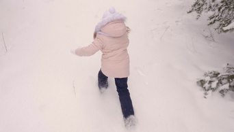 快乐的少女落在雪地上躺在地上像天使一样俯瞰雪景