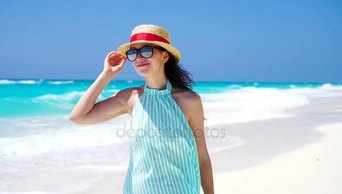 美丽的女人微笑着着暑假的到来快乐在白色的沙滩上快乐的女孩走在夏天的衣服慢动作