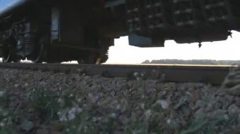 旅客列车经过火车沿着铁轨前进移动轮子特写镜头