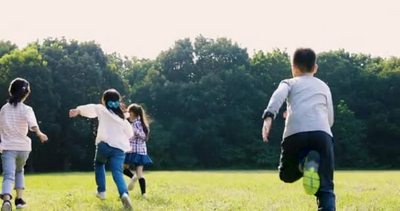 小学生在草地上跑步的后视镜