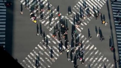 4K在夕阳西下的道路交叉口俯瞰人群中的人行横道