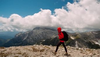 4k实拍受到鼓舞的女游客背着背包爬上高山的最高峰