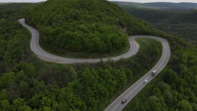 空中俯瞰公路上的汽车在春天的日子里穿过山脉的树木塞尔维亚的T