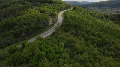 空中俯瞰公路上的汽车在春天的日子里穿过山脉的树木塞尔维亚的T