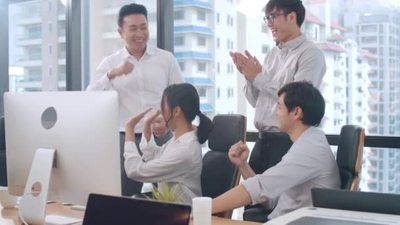4k实拍年轻的商务男女在电脑前庆祝成功