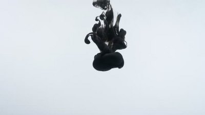 黑色墨水滴在水中旋转的特写运动拍摄