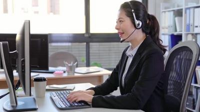 呼叫中心商务女士用耳机说话亚洲女性在客户服务岗位上通话4K