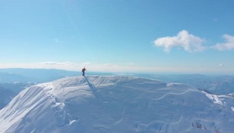 航拍一个攀爬爱好者在雪山顶端