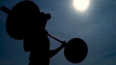 关闭拍摄的男子剪影与杠铃户外工作举重健身运动