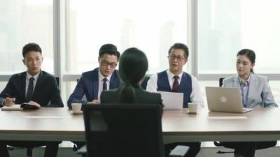现代战争残酷实拍视频素材4K一个年轻的亚洲女商人在现代公司的会议室接受一群人力资源经