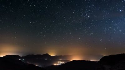 在群山繁茂的夜空中数百万的星空缓缓地掠过乡村和城镇