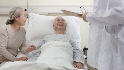 4k实拍两名年轻的亚洲医生在医院病房里巡视老年病人