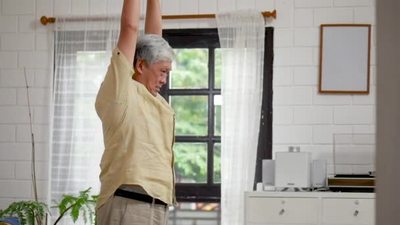亚洲老人在在家里的客厅锻炼